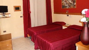 A hotel room with two beds, a TV, a painting, and a vase with flowers. - Hotel Bella Napoli (Naples)