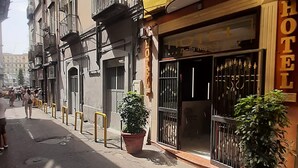A hotel with a yellow facade, a balcony with a flag, and a sign that reads "HOTEL". - Hotel Bella Napoli (Naples)
