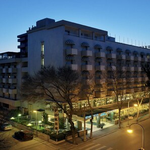 A hotel with a modern design, featuring a flat roof and a series of balconies.
