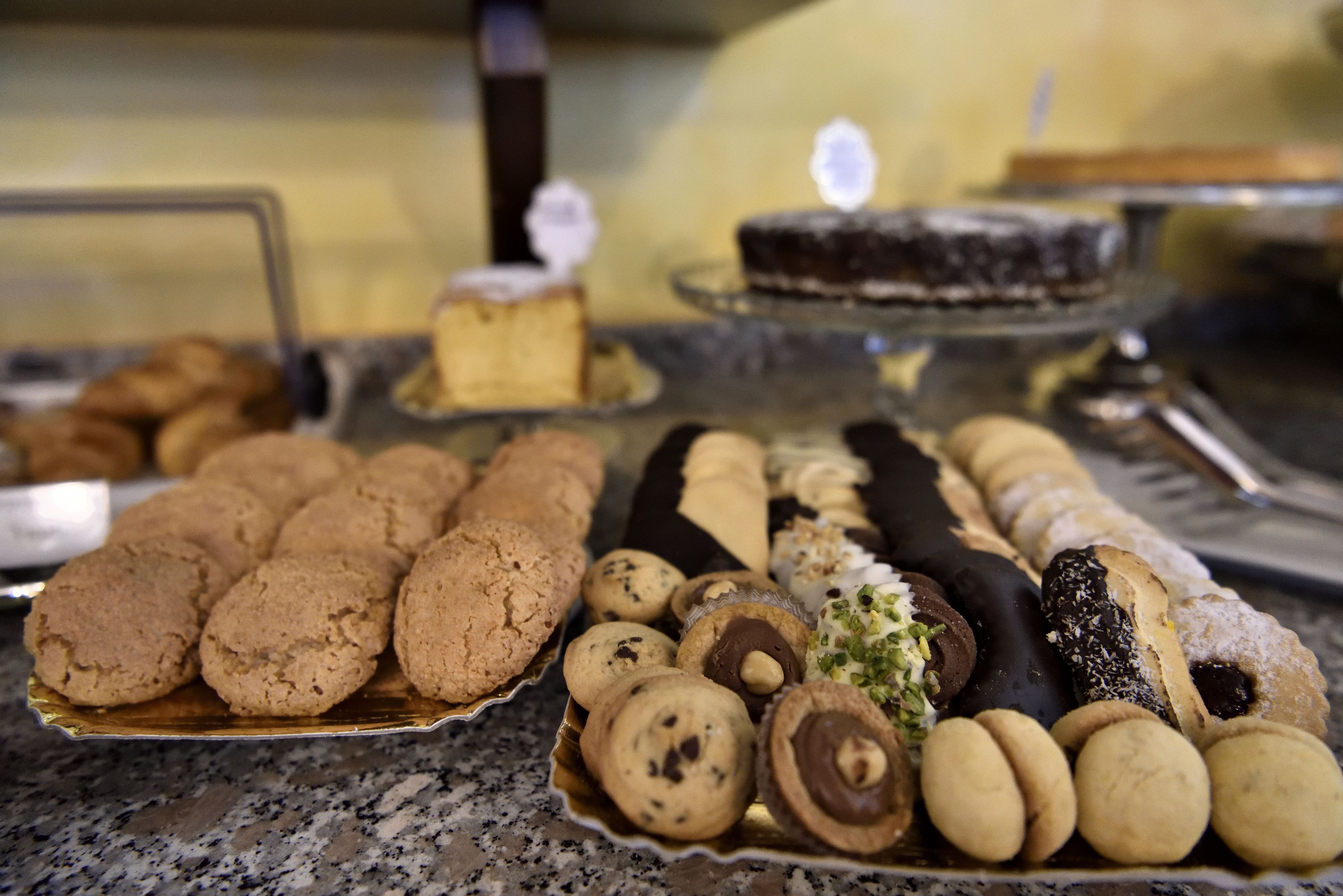 Variedad de postres a la vista, como galletas, bombones de chocolate y una tarta en un plato de servir.