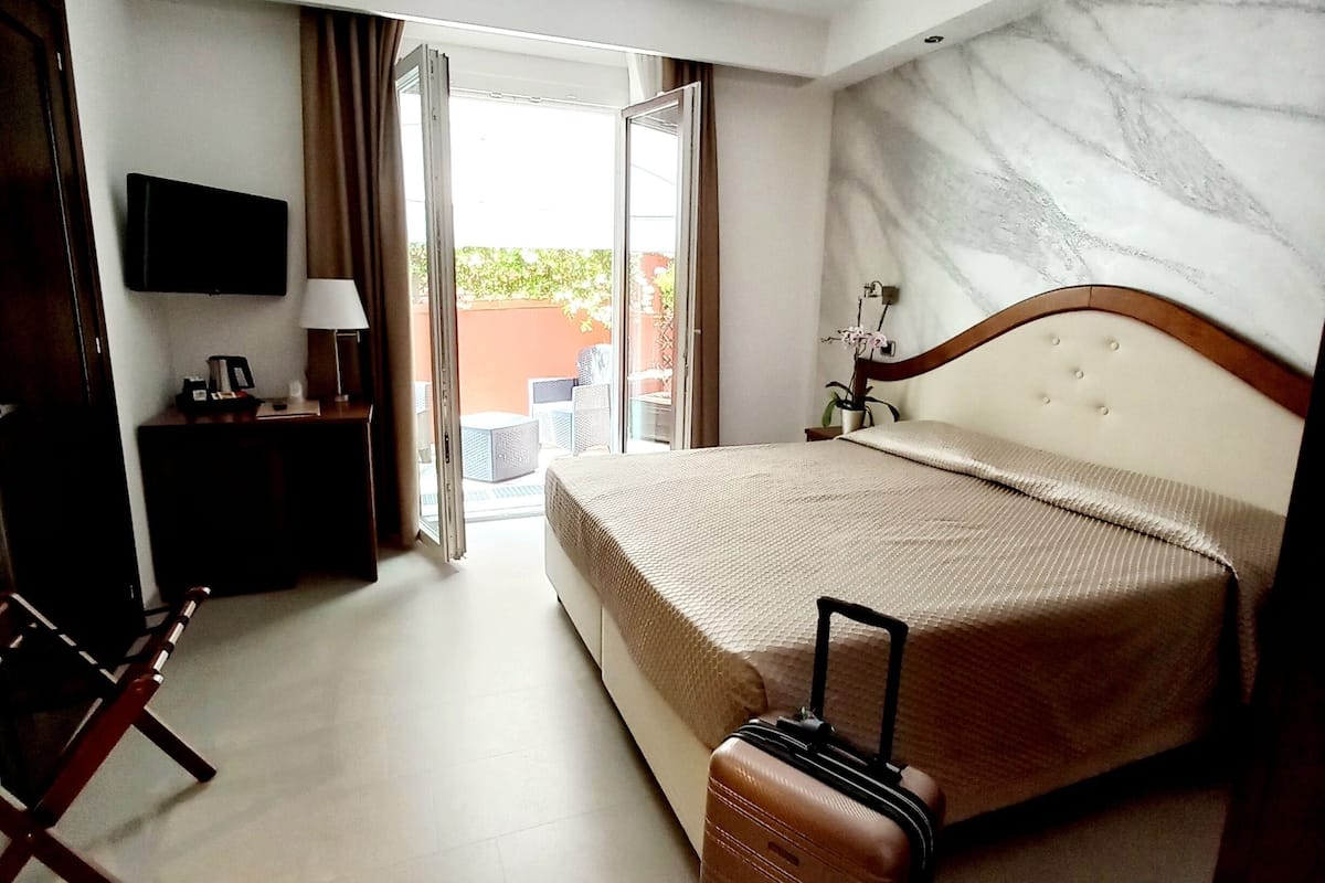 Camera con letto matrimoniale o 2 letti singoli con patio | Bar mini, peti besi dalam bilik, meja, langsir/tirai gelap terus