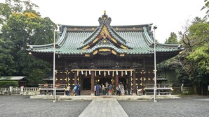 Um edifício japonês tradicional com telhado verde e detalhes dourados.