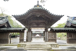 Un portón tradicional japonés con intrincados detalles de madera y un emblema central.