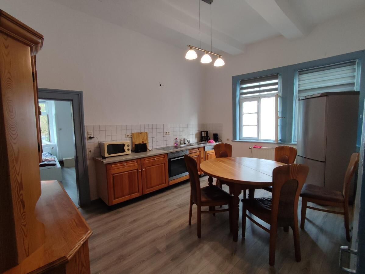 Una cocina moderna con armarios de madera, una mesa de comedor y una ventana con persianas.