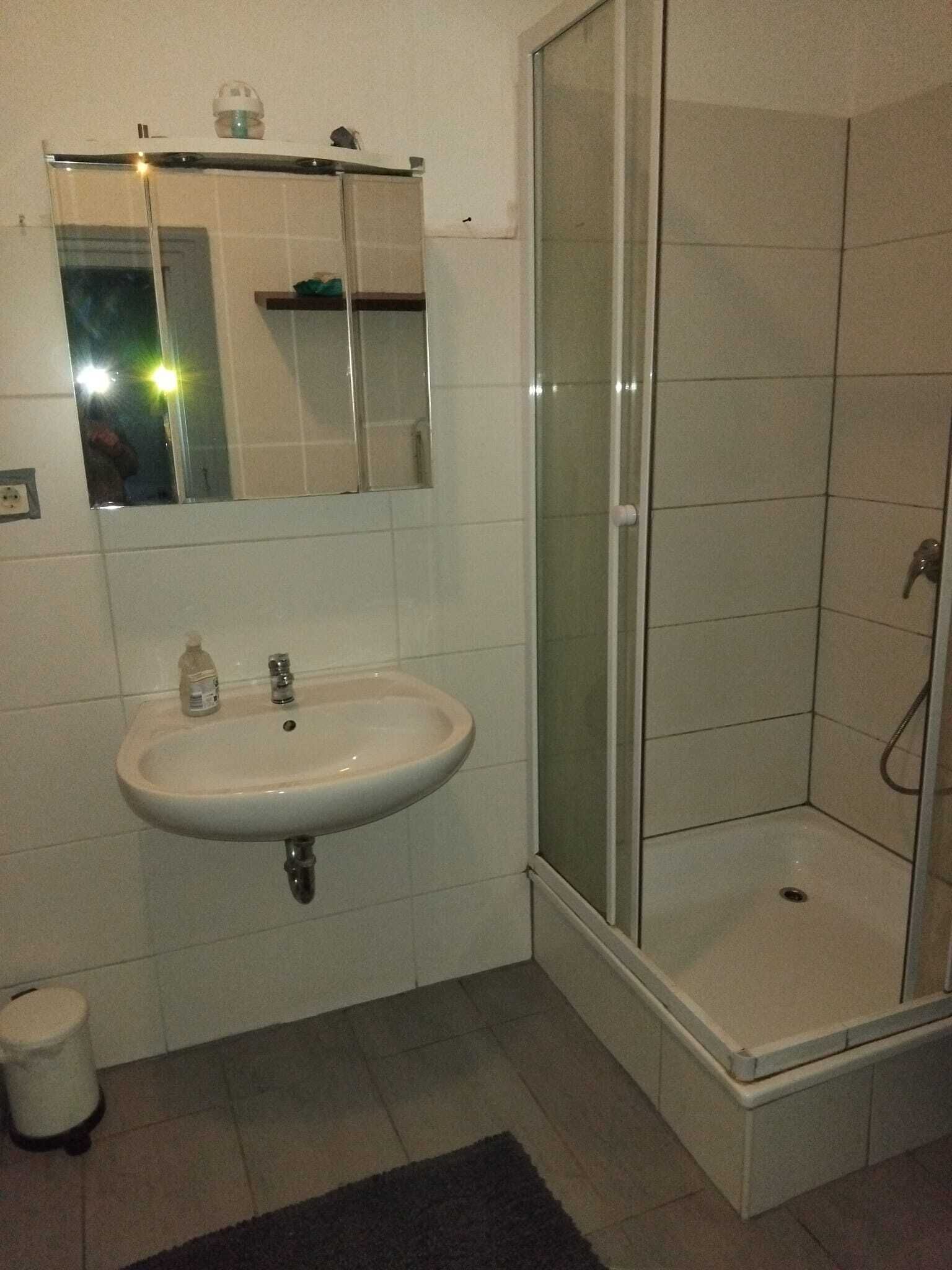 Ein Badezimmer mit Waschbecken, Spiegel und Dusche.