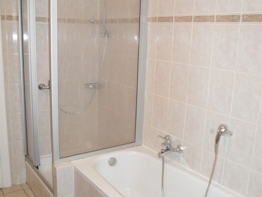 Un bagno con doccia vetrata, vasca e soffione.