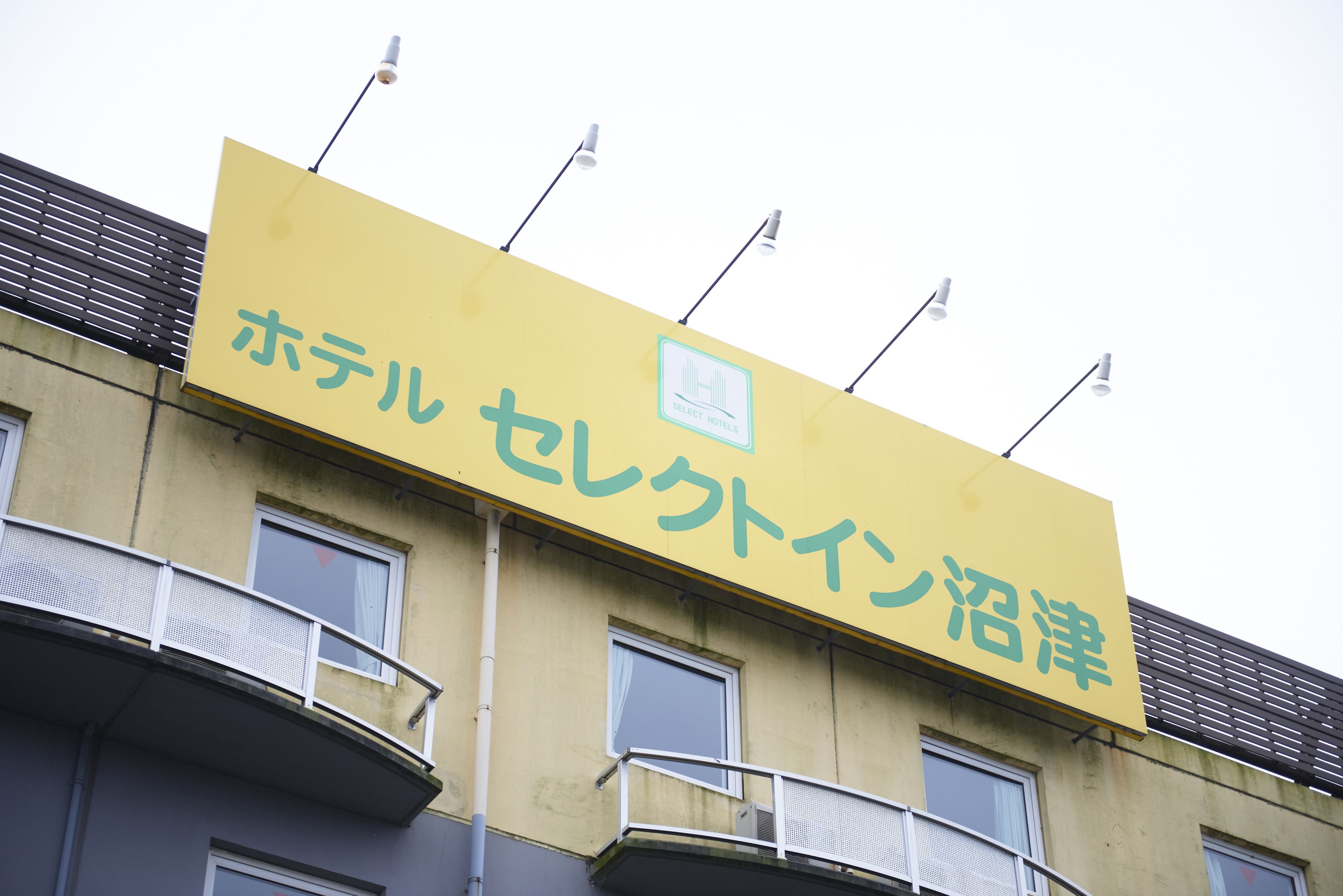 A yellow sign with Japanese characters for "Hotel Secluded in Koshien."