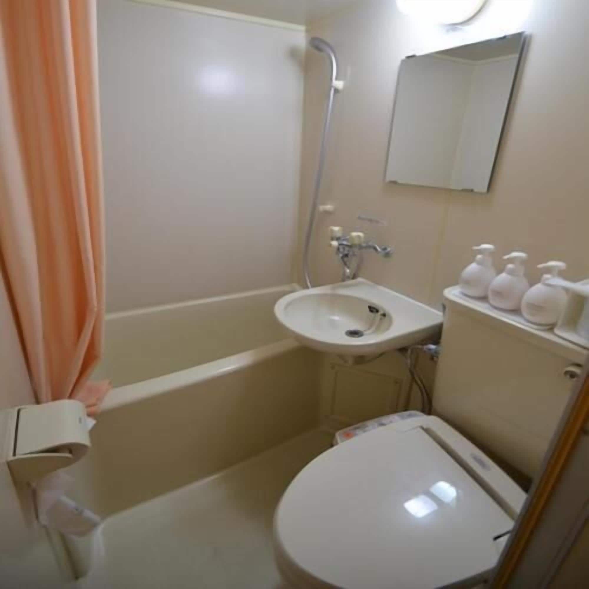 A bathroom with a bathtub, sink, toilet, and a mirror.