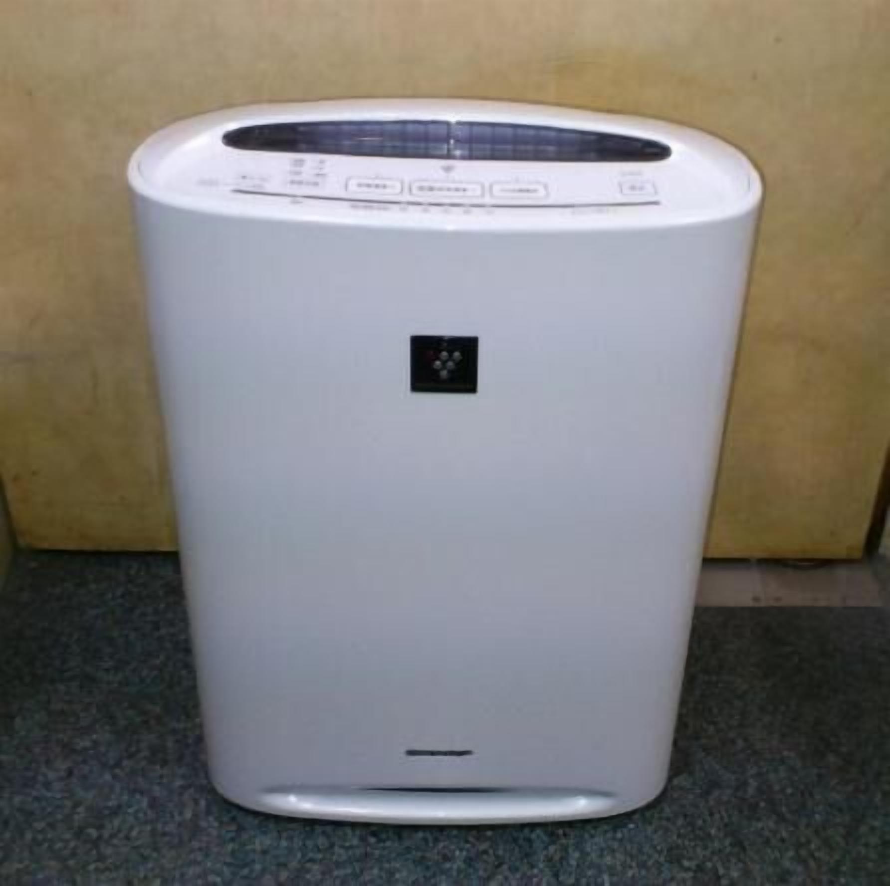 A white, standalone air purifier with a control panel at the top and a small display in the center.