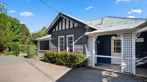 A two-story building with a porch and a covered outdoor seating area. - Bundanoon Hotel (Bundanoon)