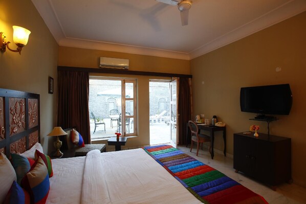 Une chambre d’hôtel avec un grand lit, un bureau, une télévision et une vue sur l’extérieur.