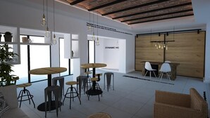 Ein modernes Interieur mit freiliegenden Ziegeldecken, runden Holztischen und unterschiedlichen Sitzgelegenheiten.