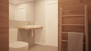 A modern bathroom with a toilet, sink, and wooden vanity.