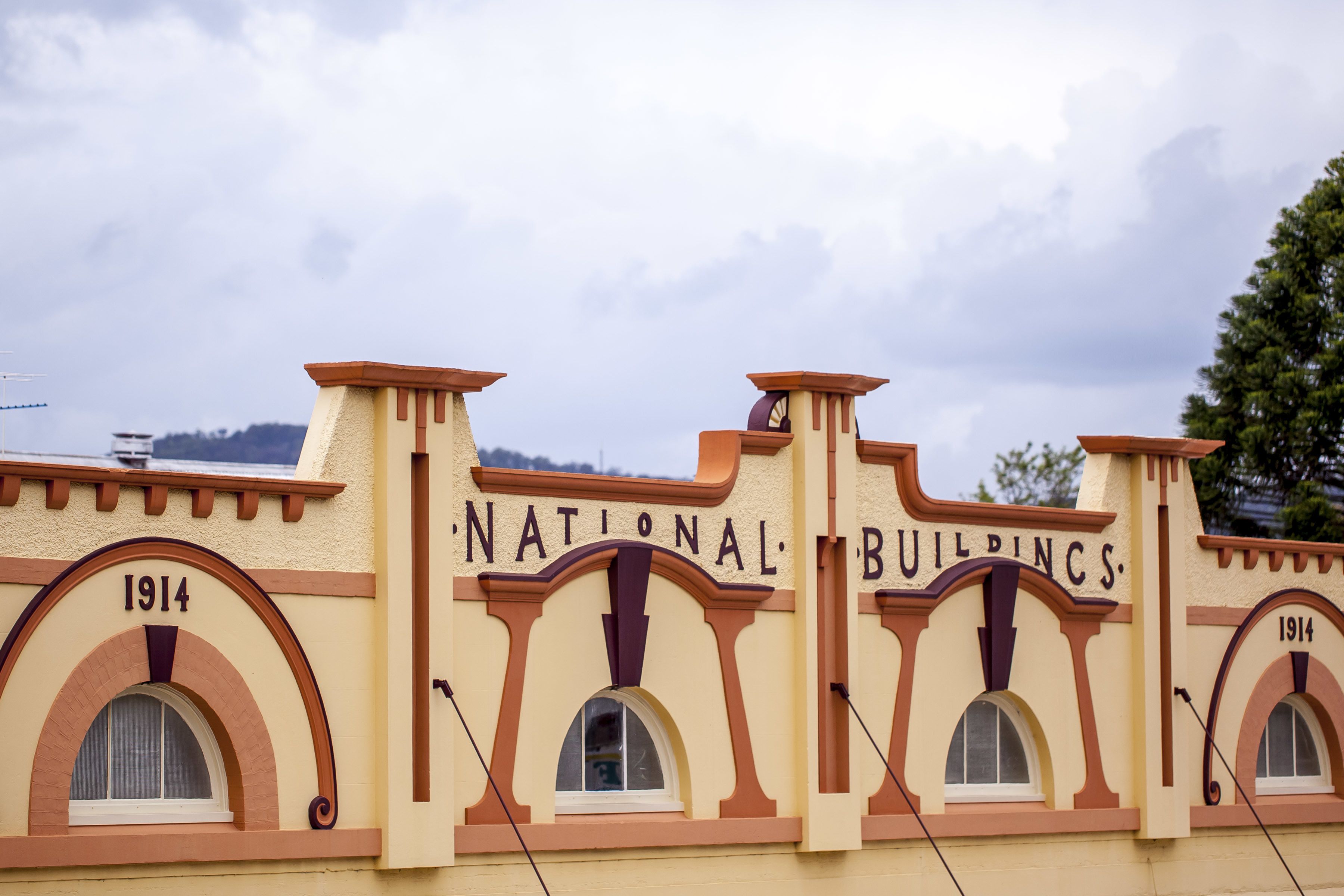 Fachada de un edificio con el texto "NATIONAL BUILDINGS" y el año "1914" bien visibles.