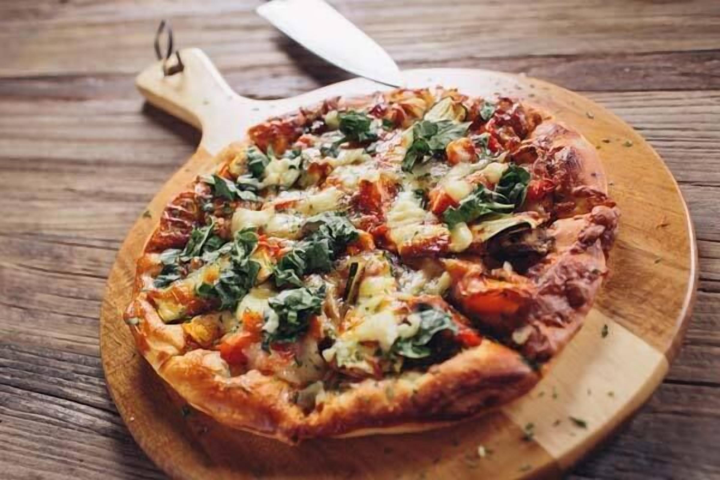 A pizza on a wooden board.