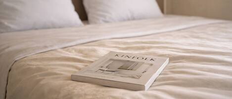 Una cama bien hecha con un libro titulado 'KINFOLK'.