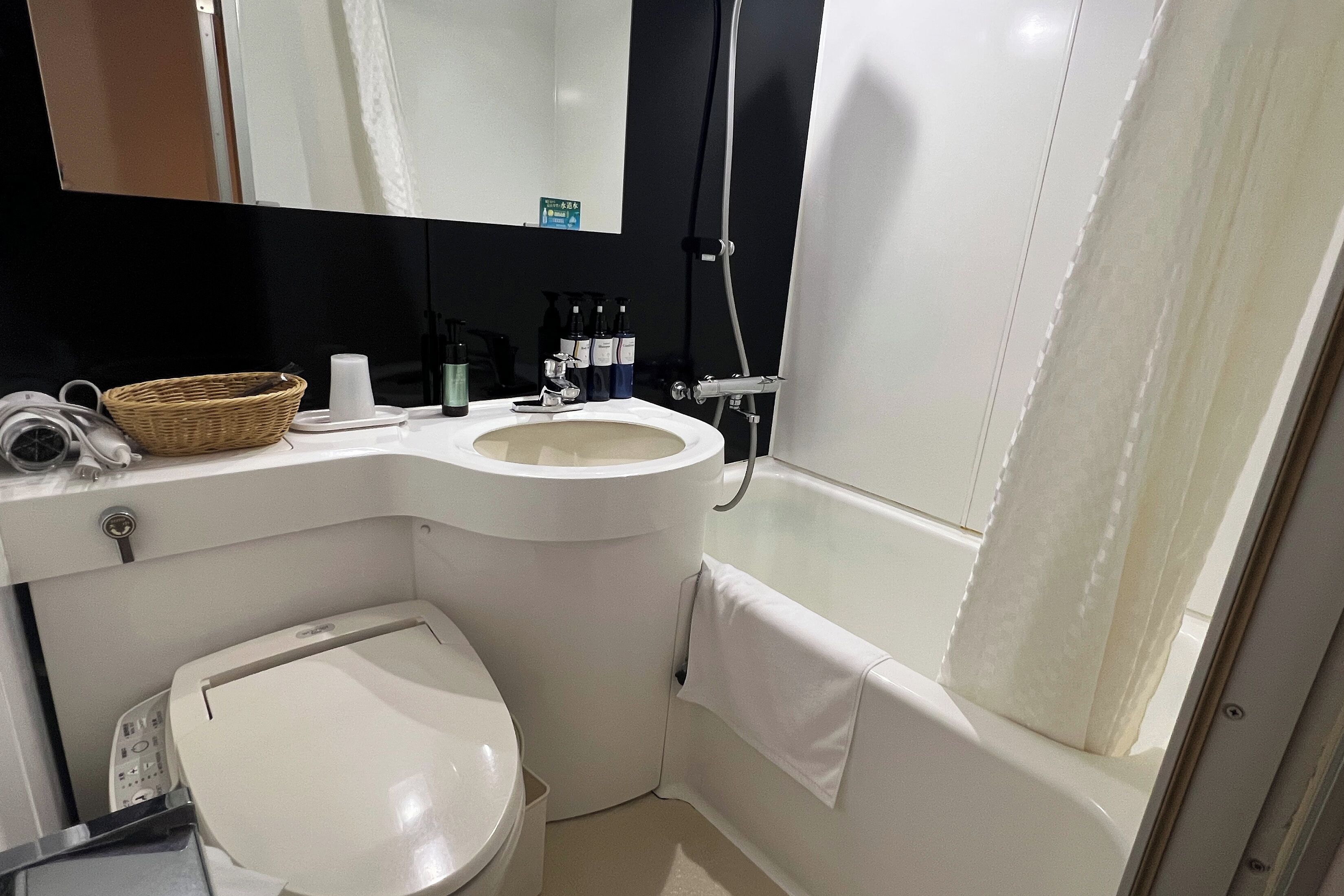Un baño con inodoro, lavamanos y ducha.