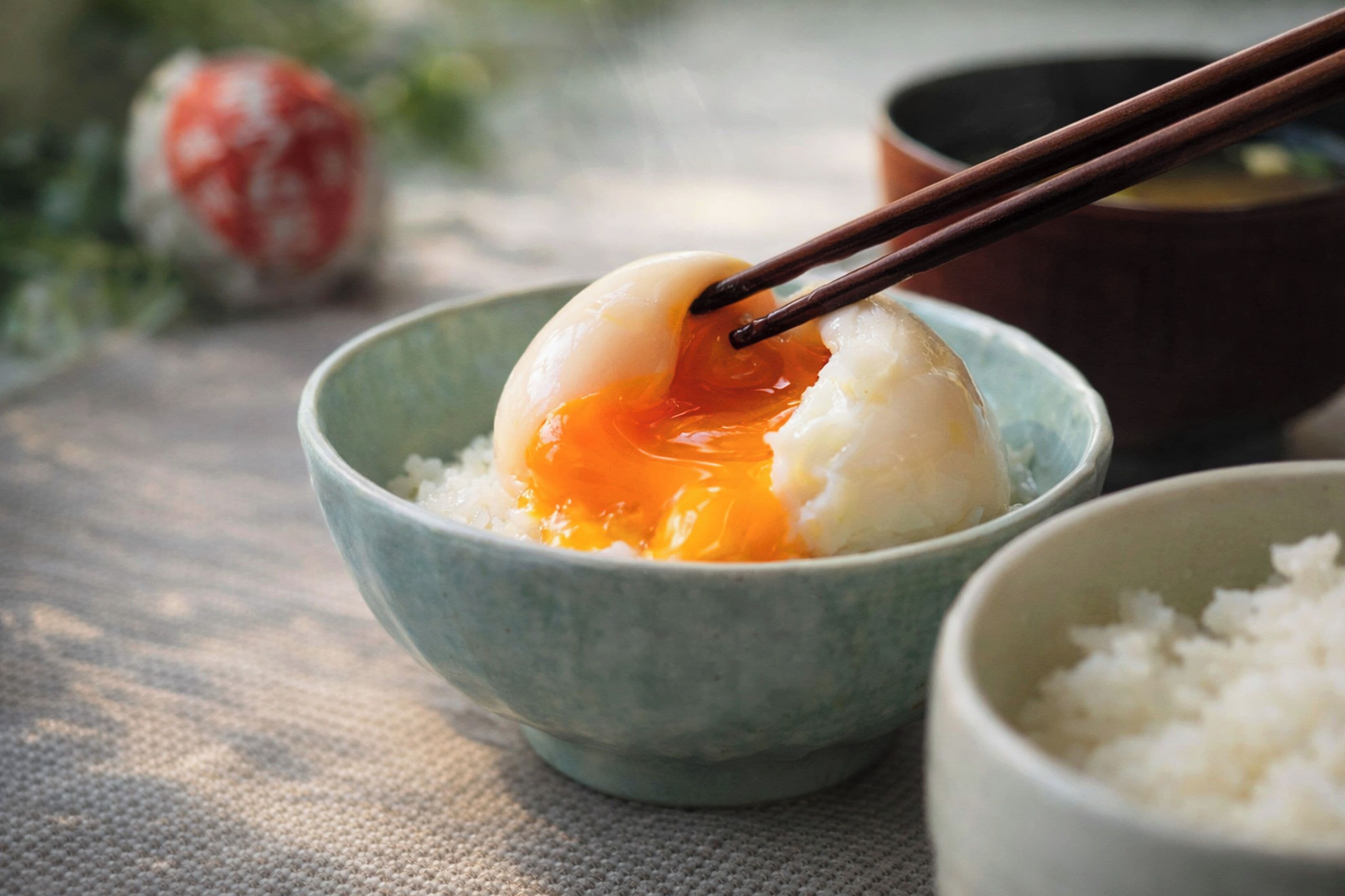 A bowl of rice with a dumpling and chopsticks.