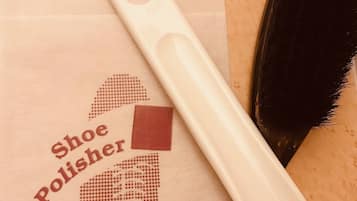 Una bolsa para lustrar zapatos, un cepillo y un zapato de madera.