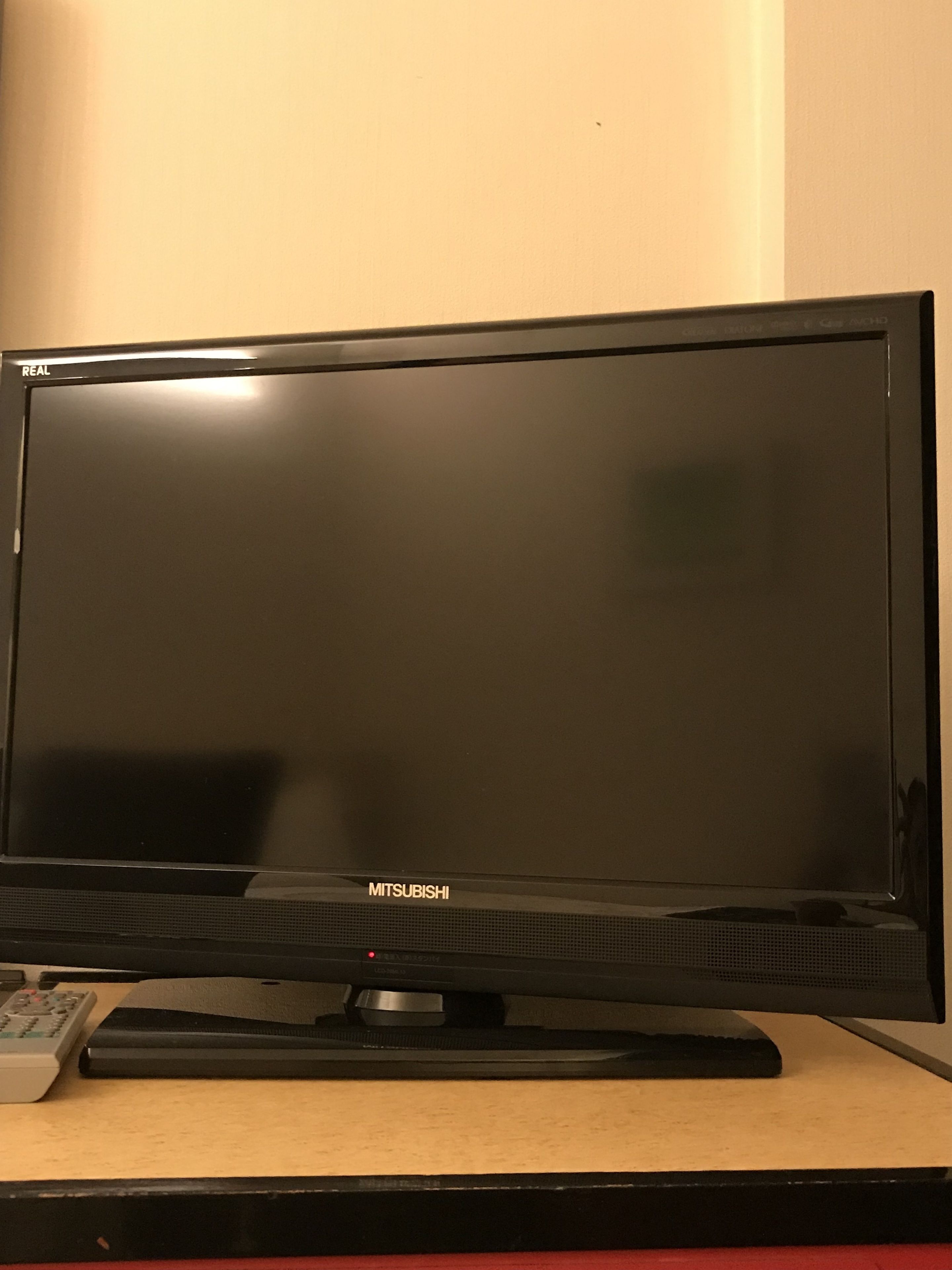 Een flatscreen televisie op een standaard, compleet met afstandsbediening en toetsenbord.