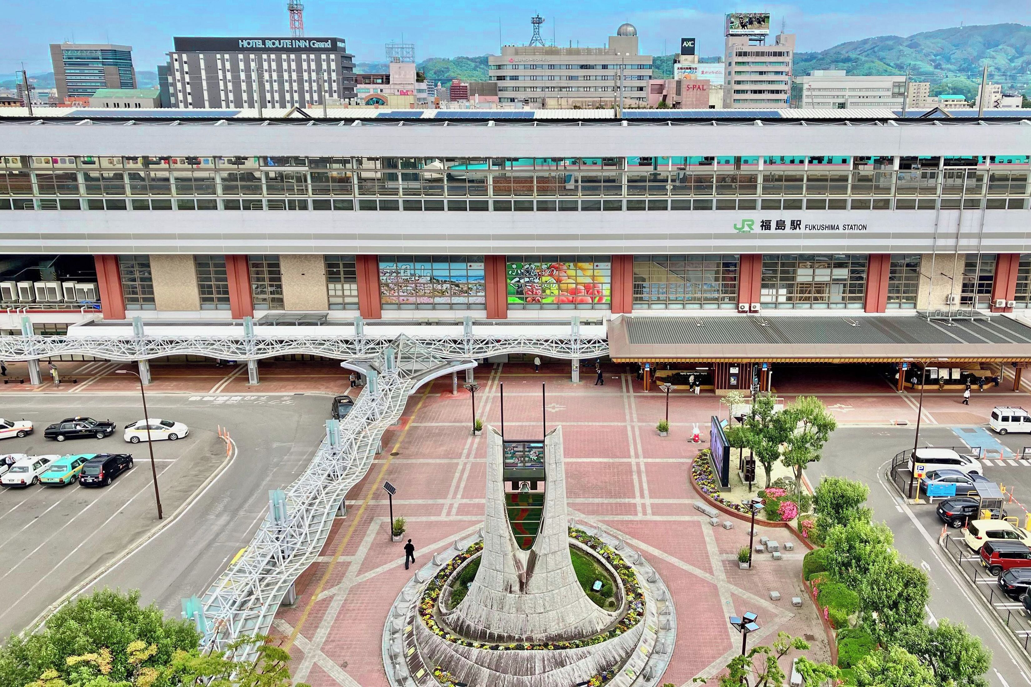 A multi-story building with a central atrium, a parking area, and a distinctive fountain.