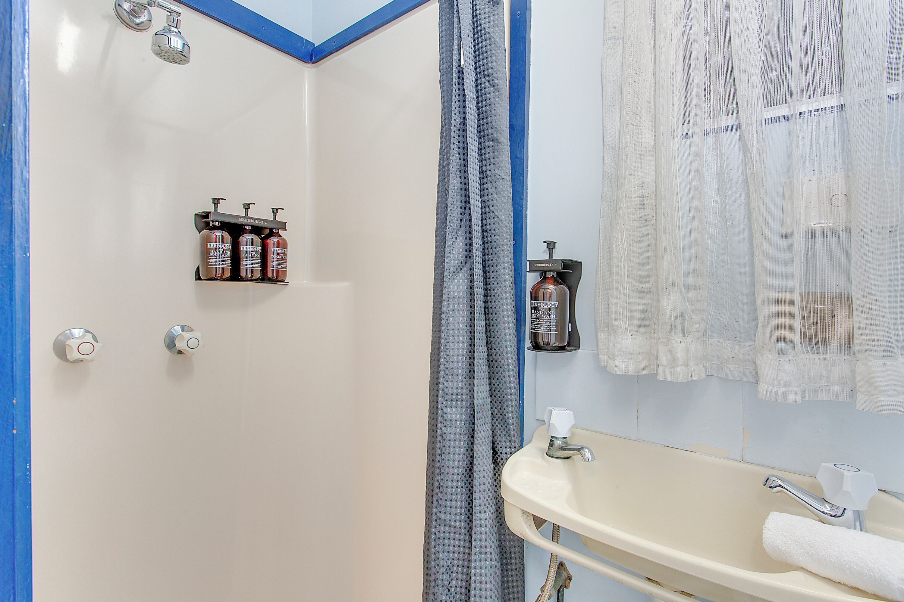 Ein Badezimmer mit Dusche, Waschbecken und Handtuchhalter.