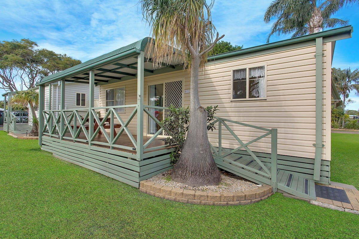 A single-story house with a covered porch and a small garden area.