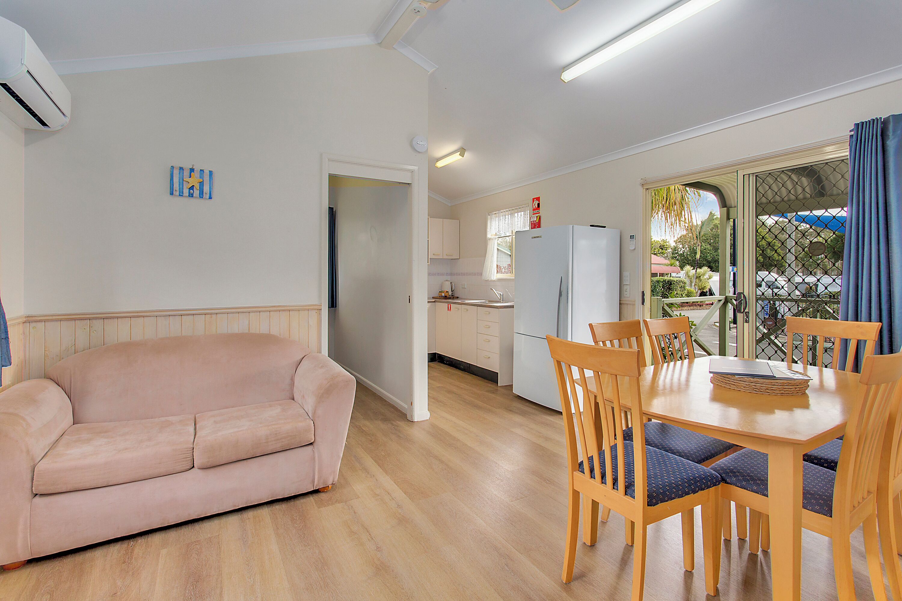 A living room with a sofa and a dining area with a table and chairs.