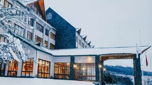 A modern building with large windows and a snow-covered roof.