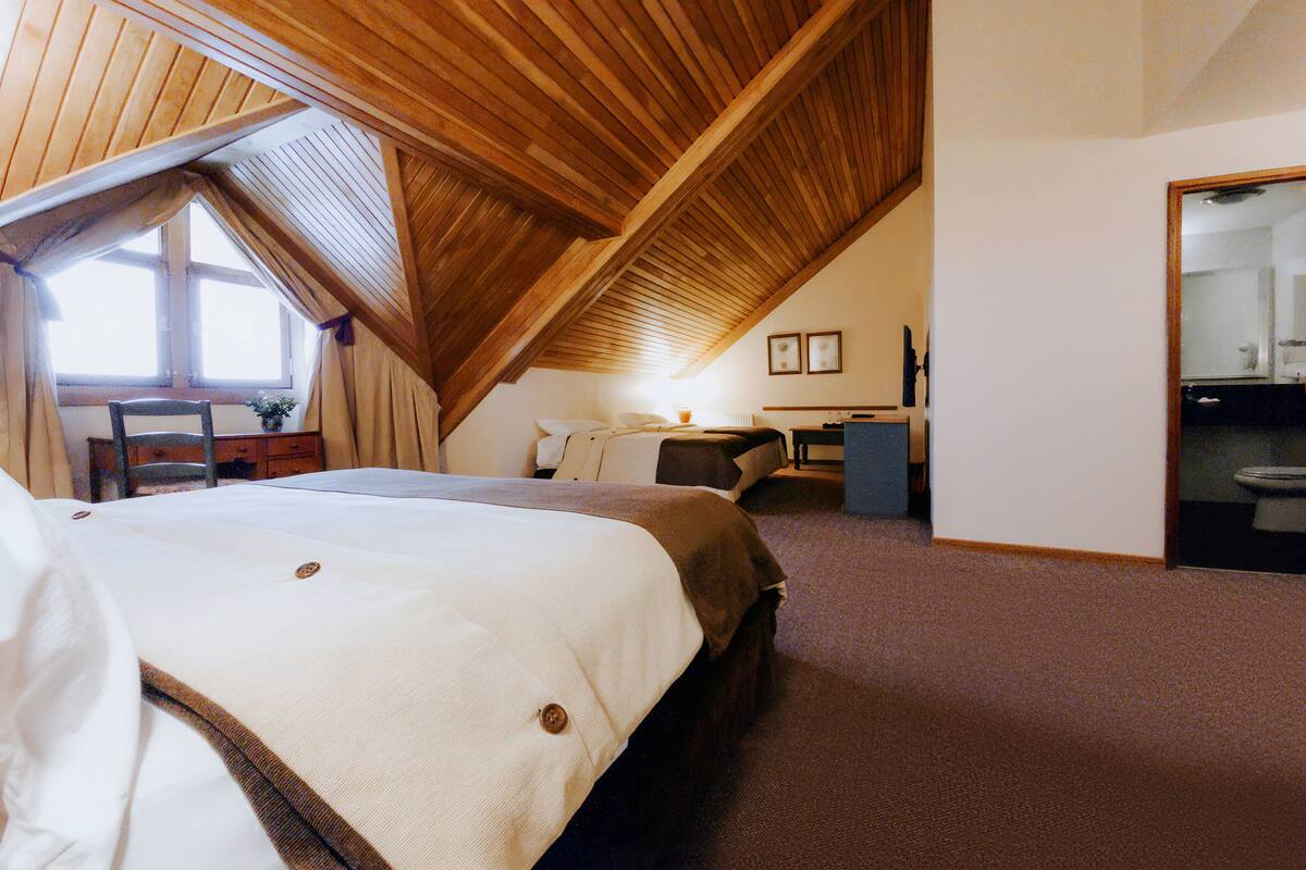 Ein Schlafzimmer mit einem großen Bett, einem Schreibtisch und einem Stuhl.