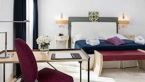 A hotel room with a bed, bedside tables, a desk, a chair, and a vase with flowers. - Is Arenas Resort (Narbolia)