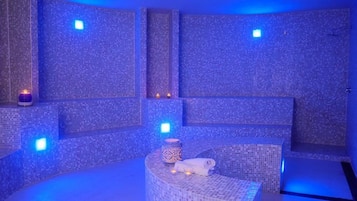 Relax in a serene spa room with a curved bench and mosaic tile walls.