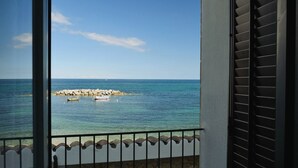 A balcony with a view of the sea, a rocky outcrop, and a few boats. - Tonnara di Trabia (Trabia)