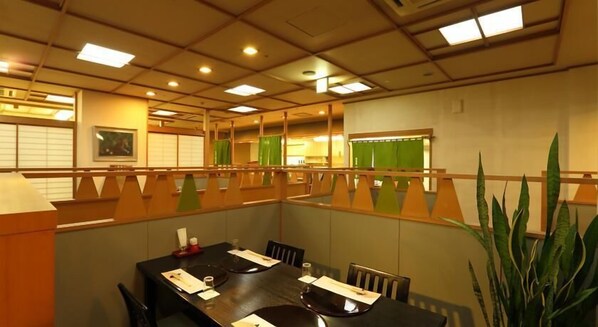 A conference room with a long table, chairs, and a large potted plant. - Select Grand Ise Shima (Shima)