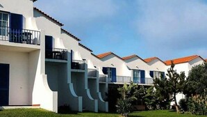 Une rangée de bâtiments blancs, avec des toits recouverts de tuiles rouges et des balcons.