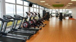Une salle de sport équipée de tapis de course, de vélos elliptiques et de matériel de musculation.
