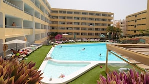 A hotel pool area with multiple levels of balconies, a swimming pool, and sun loungers. - Apartamentos Amazonas (San Bartolomé de Tirajana)