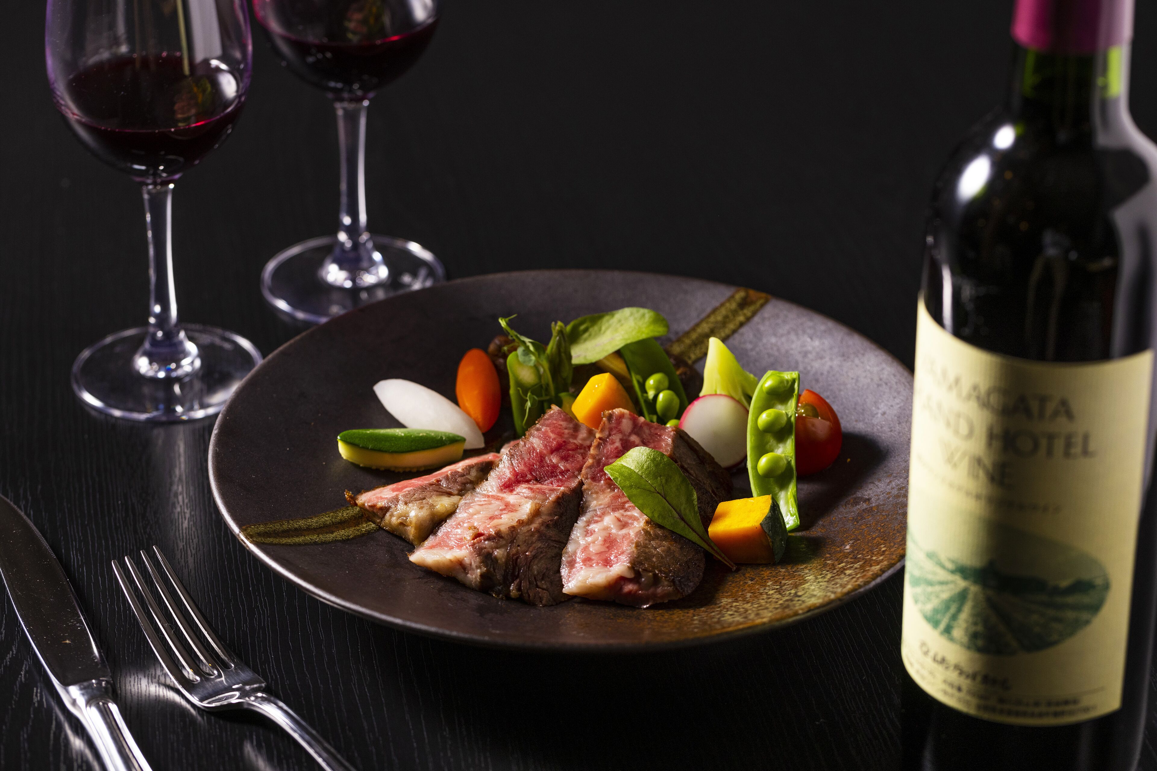 A plate of food with a bottle of wine on a table.