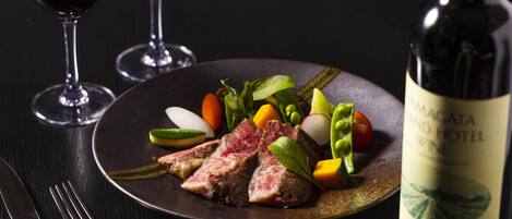 A plate of food with a bottle of wine on a table.