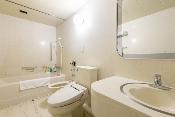 A modern bathroom with a bathtub, toilet, and sink.