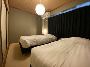 A hotel room with two beds, a ceiling fan, an air conditioning unit, and a large window with curtains. - Randor Residence Tokyo Classic (Tokyo)