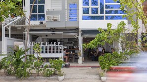 Un edificio de dos pisos con una cafetería llamada 'WHITE HARP' en la planta baja.