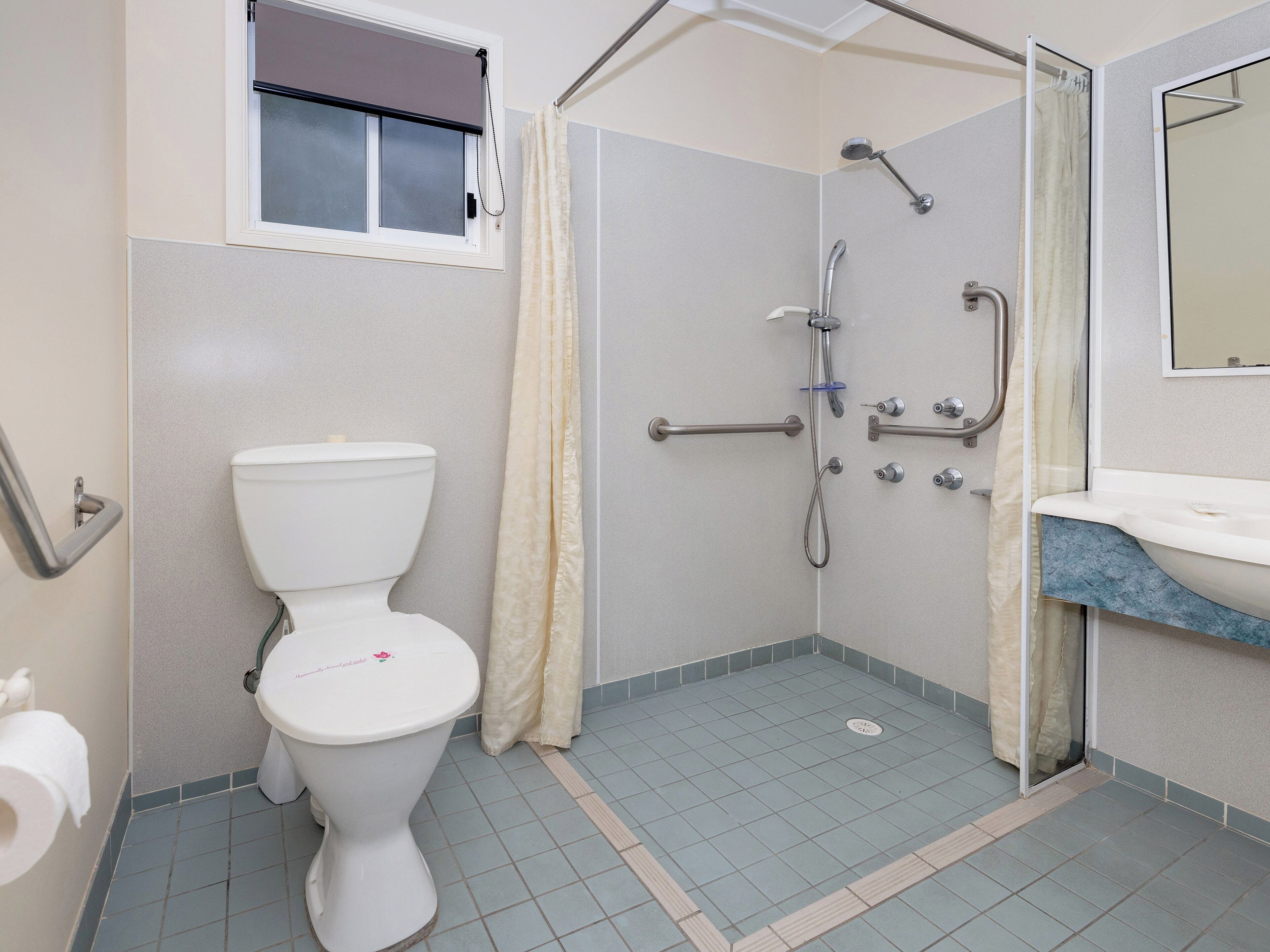 Une salle de bain avec des toilettes, une douche et un lavabo.