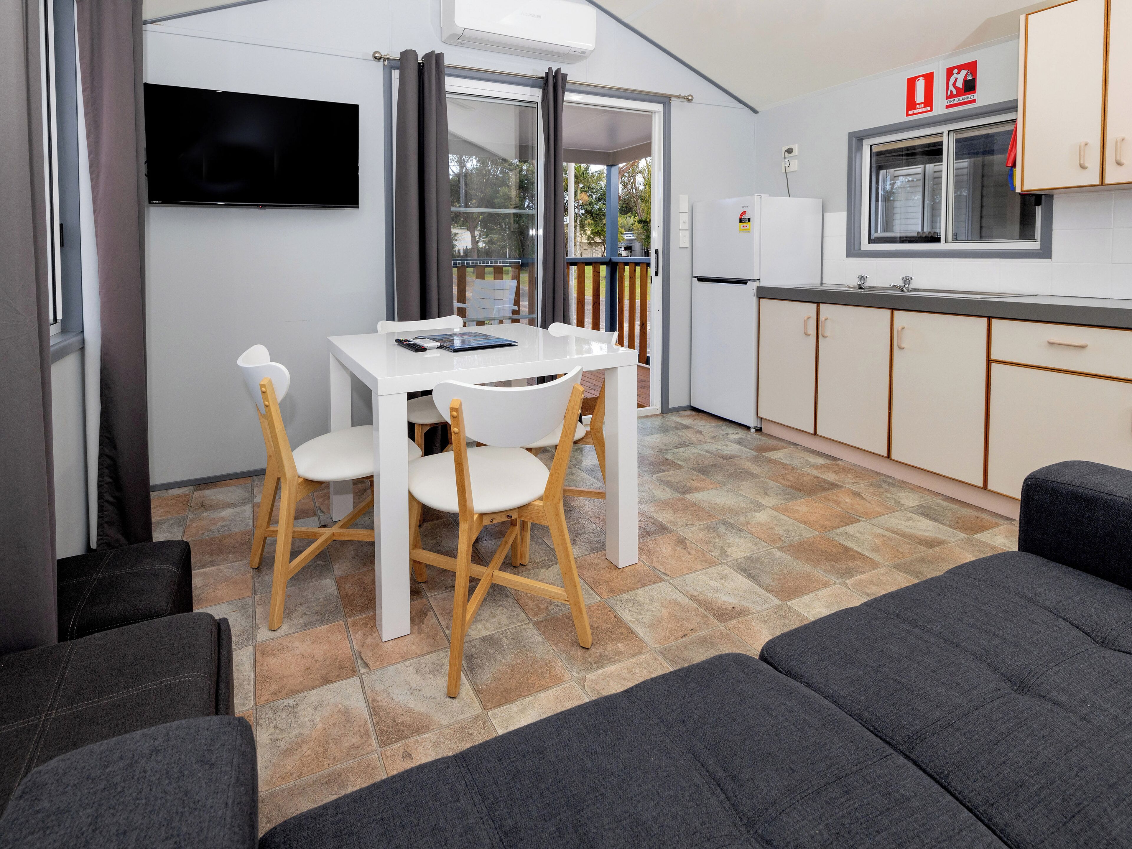 A compact kitchenette with a refrigerator, a sink, and a window.