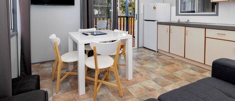 Una kitchenette compacta con refrigerador, lavamanos y ventana.