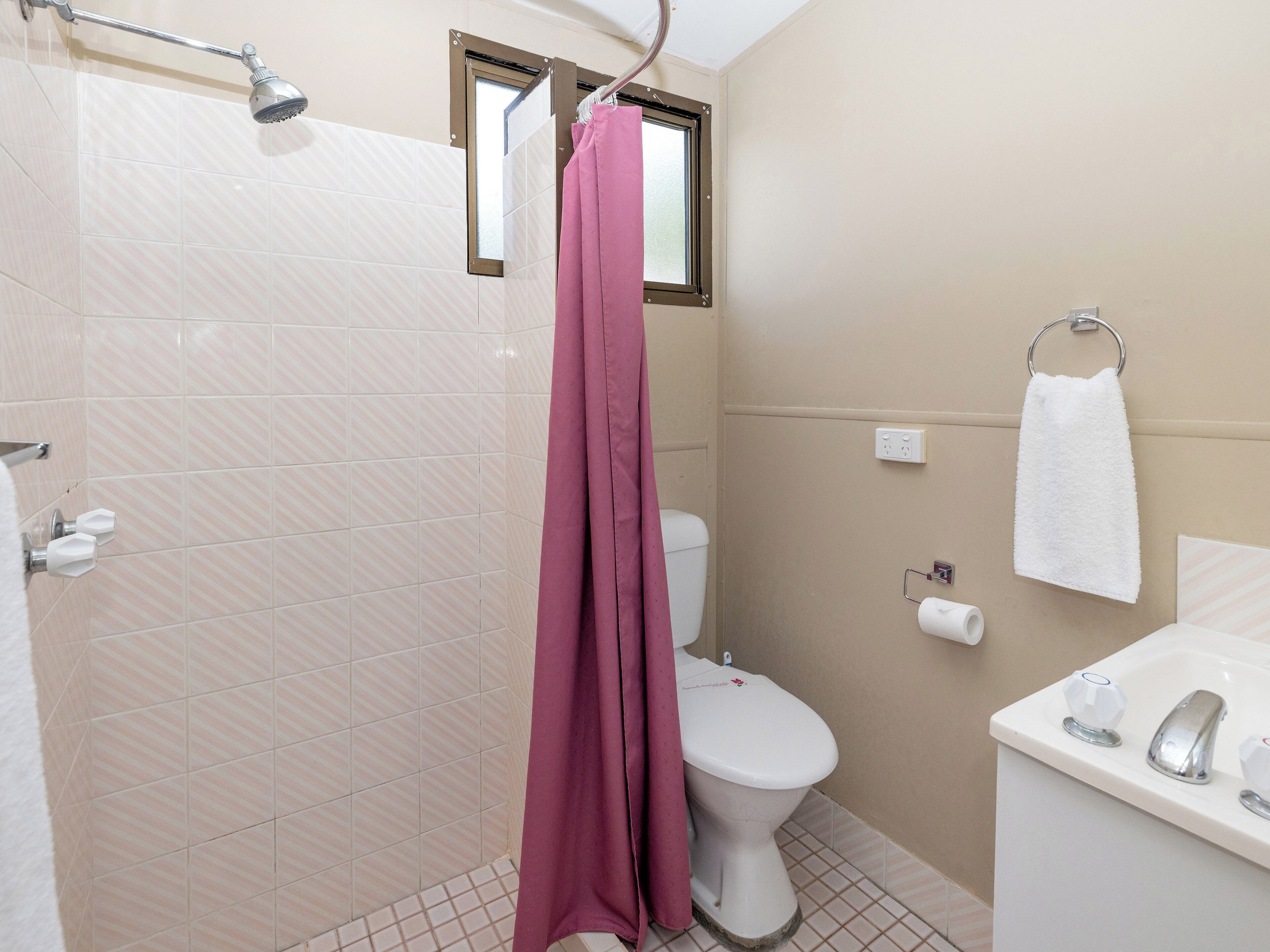 Un baño con ducha, inodoro y lavamanos.