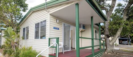 A small, single-story building with a porch, a window, and a sign reading 'Beachcomber.'