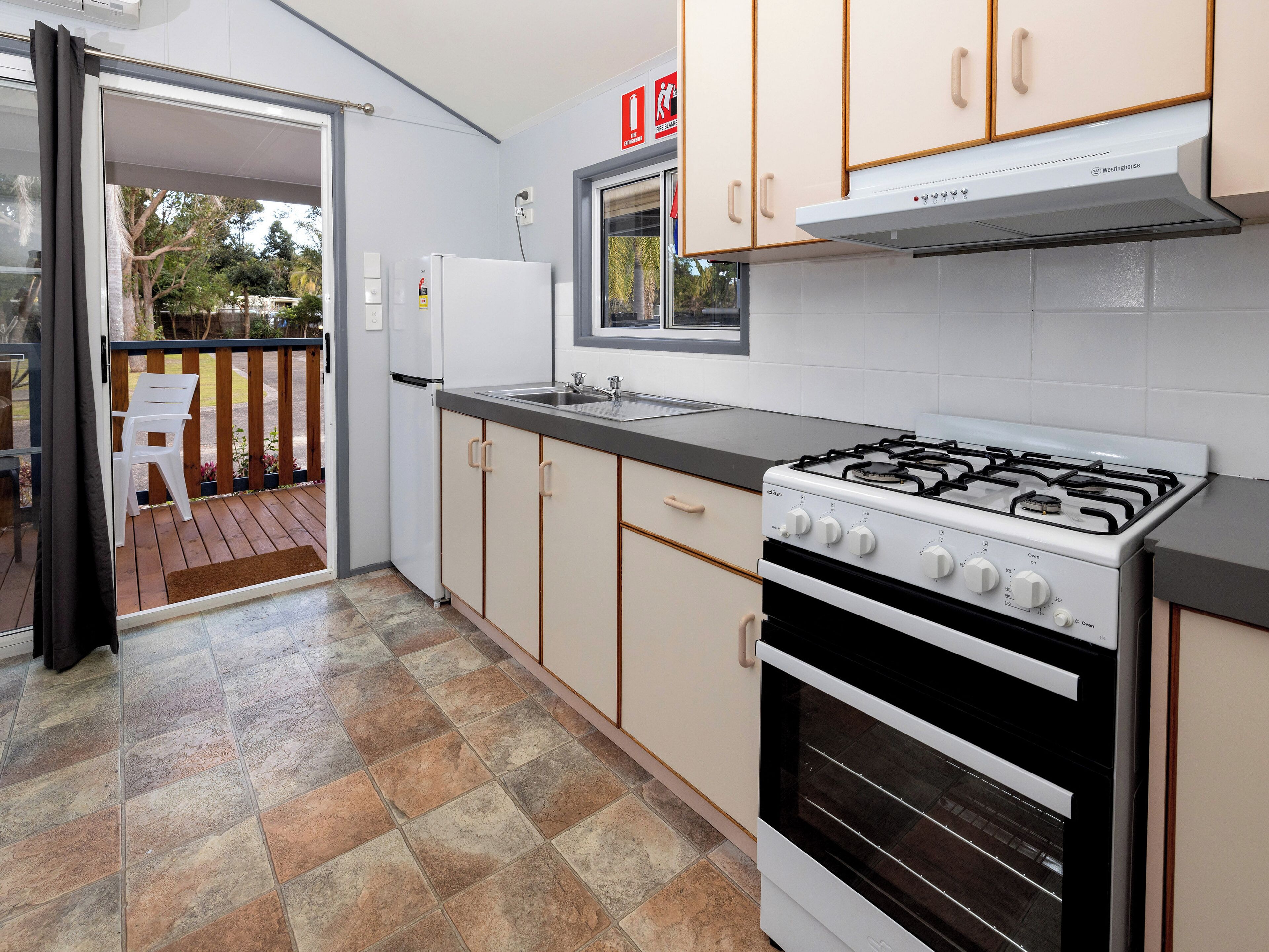 A kitchen with a gas stove, oven, and a refrigerator.