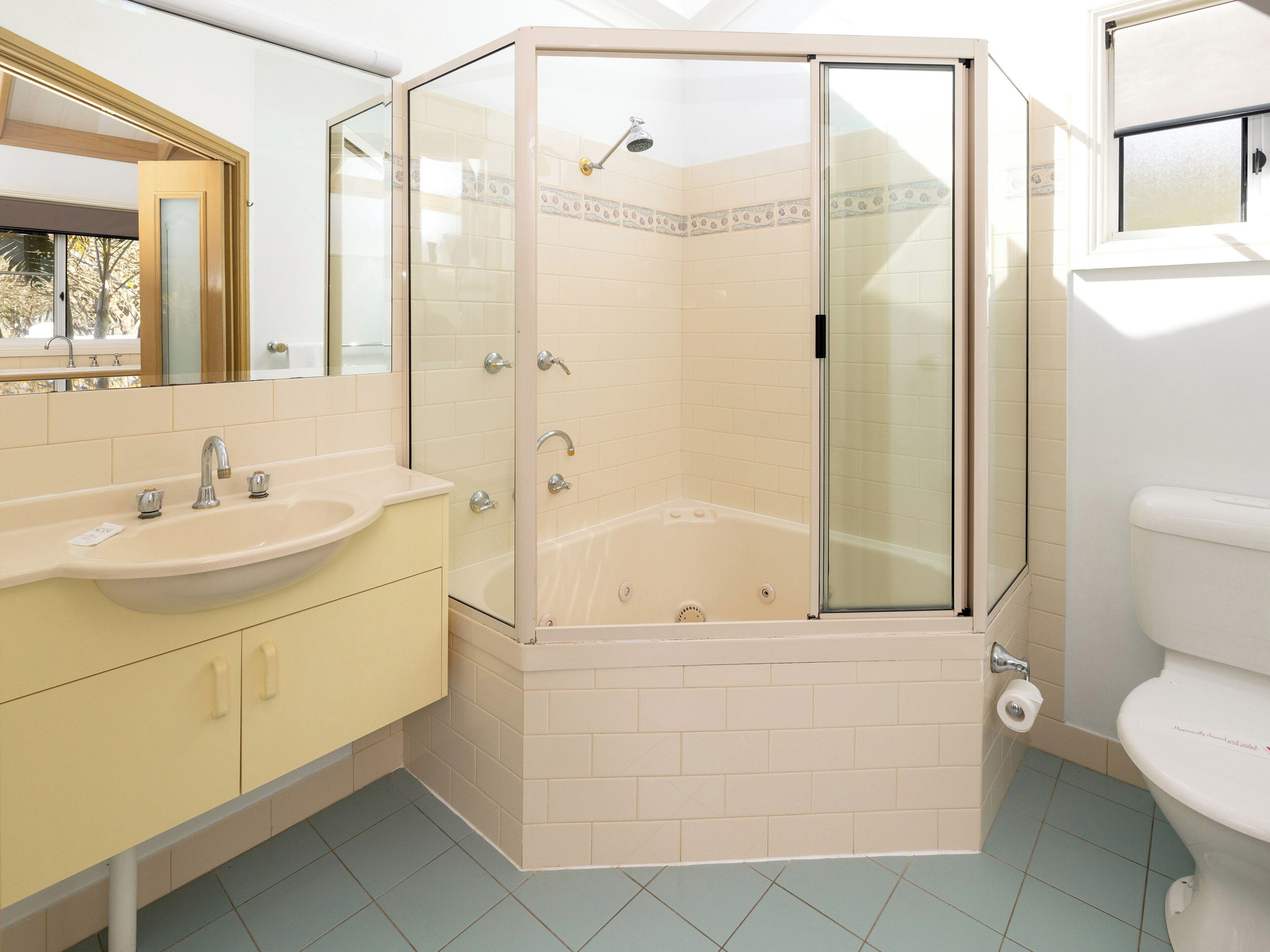 A bathroom with a glass-enclosed shower, a bathtub, a sink, and a toilet.