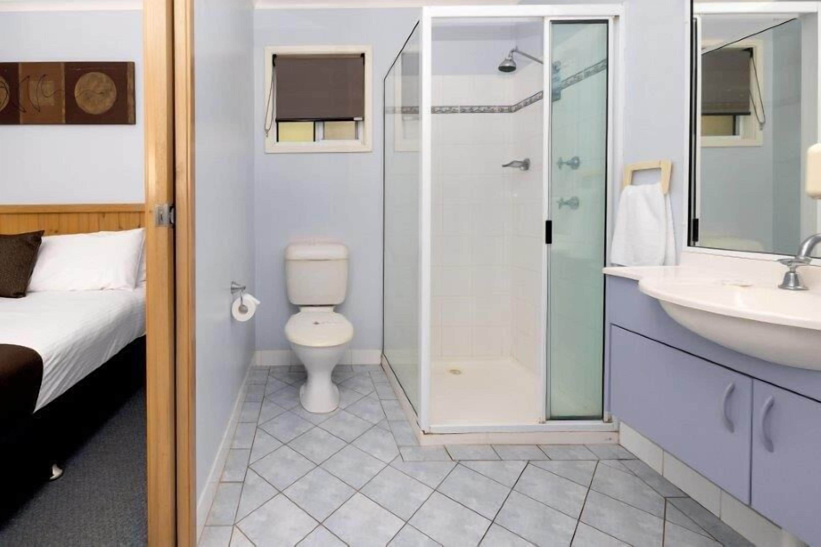 Une salle de bain avec des toilettes, une douche et un lavabo.